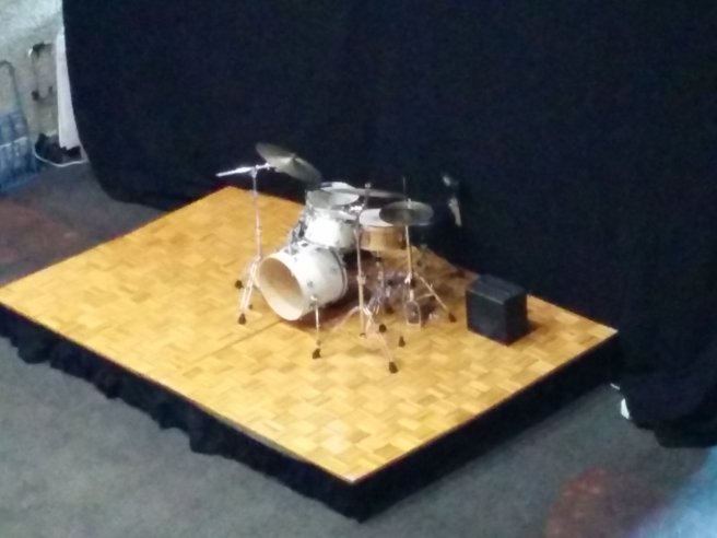 A drum set sitting maybe 100 feet from where people are reading books.
